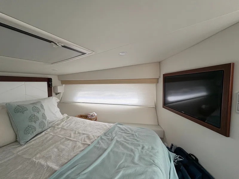 Slide: The Image of The interior of a 2024 Regal 38 Grande Coupe features a cozy bedroom with a television. - 43