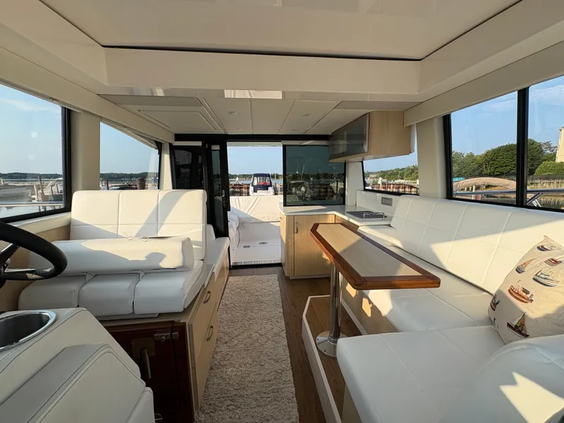 Slide: The Image of Interior of the 2024 Regal 38 Grande Coupe with sleek white seating and wooden table. - 26