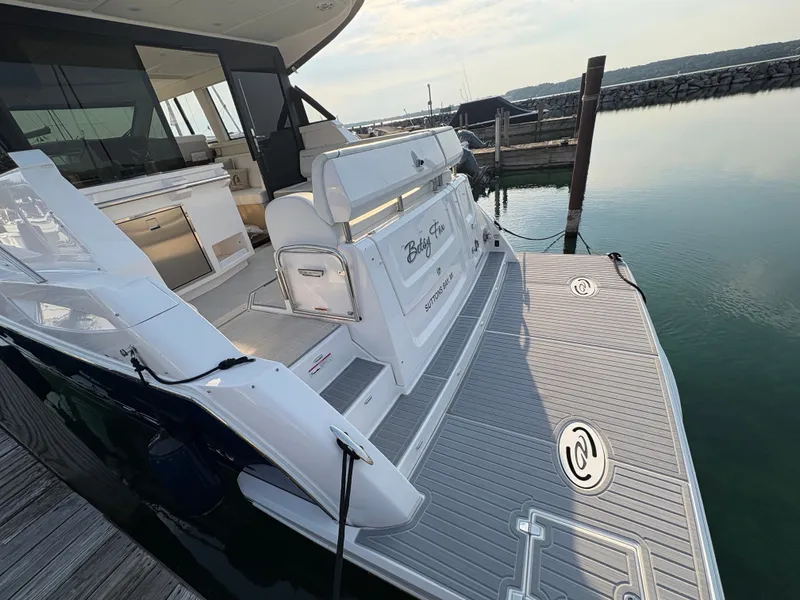 Slide: The Image of The image shows the stern of a 2024 Regal 38 Grande Coupe docked at a pier. - 34
