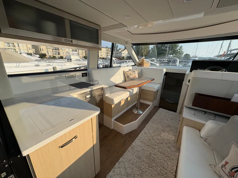 Slide: The Image of Interior of a 2024 Regal 38 Grande Coupe with modern kitchen and cozy seating area. - 6