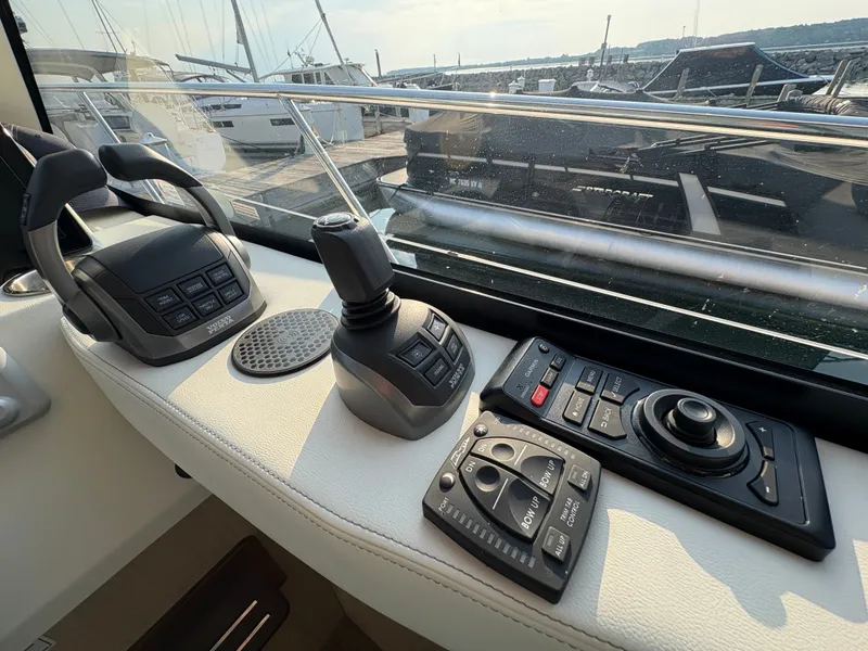 Slide: The Image of The image shows the helm of a 2024 Regal 38 Grande Coupe with modern controls. - 23