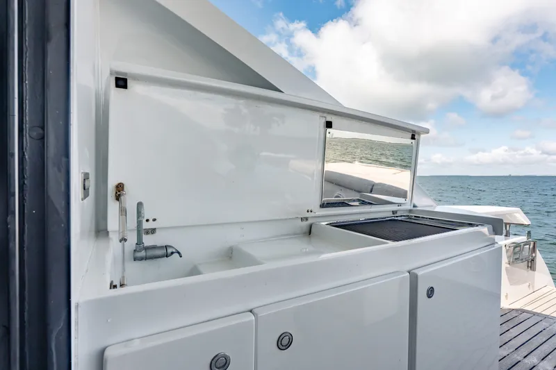 Slide: The Image of Outdoor kitchen area on 2010 Pershing 80 yacht, featuring a sink and grill with ocean view. - 29