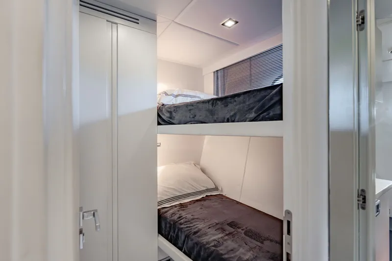 Slide: The Image of Bunk beds in a 2010 Pershing 80 yacht cabin, featuring modern design and cozy bedding. - 86