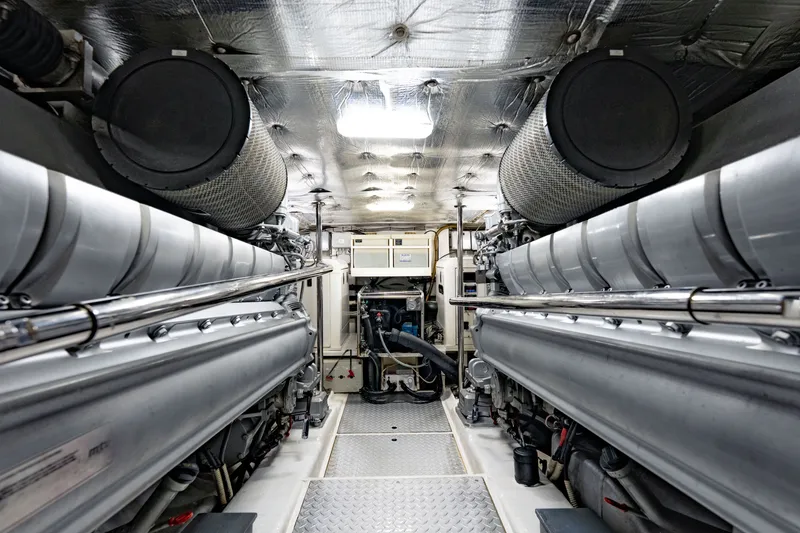 Slide: The Image of Engine room of a 2010 Pershing 80 yacht, showcasing dual engines and metallic finishes. - 96