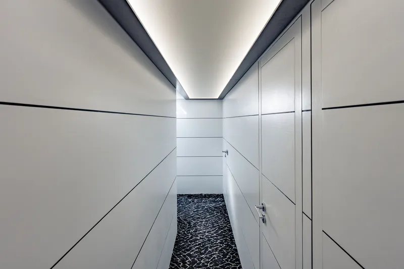 Slide: The Image of Modern interior hallway of 2010 Pershing 80 yacht with sleek white panels and patterned flooring. - 76