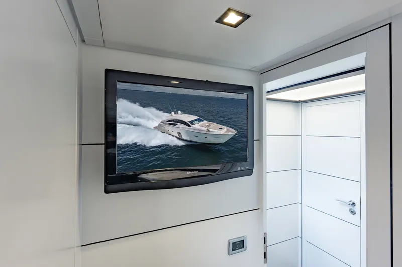 Slide: The Image of Flat-screen TV displaying a Pershing 80 yacht, 2010 model, in a modern interior setting. - 75