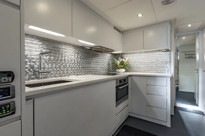 Slide: The Image of Modern kitchen interior on 2010 Pershing 80 yacht with sleek cabinetry and metallic backsplash. - 78