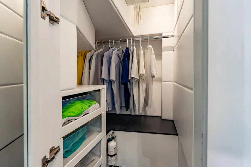 Slide: The Image of Compact closet with hanging shirts and organized shelves on a 2010 Pershing 80 yacht. - 54