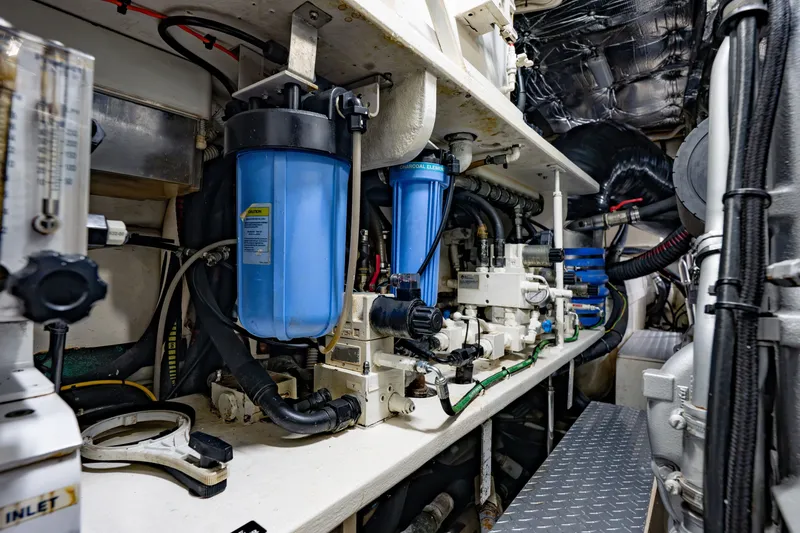 Slide: The Image of Engine room of a 2010 Pershing 80 yacht, showcasing complex machinery and filtration systems. - 99