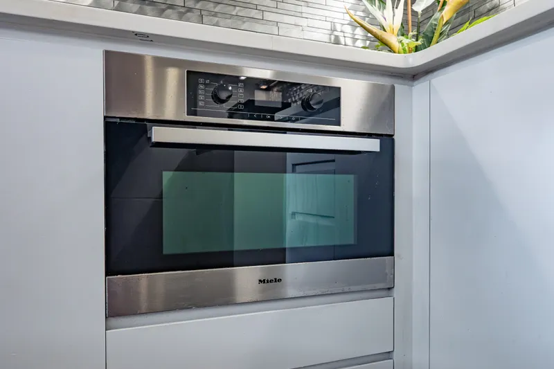 Slide: The Image of Modern Miele oven in sleek kitchen setting, featuring stainless steel design. - 81