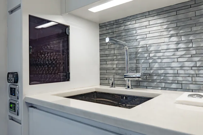 Slide: The Image of Modern kitchen sink with sleek faucet and textured backsplash on a 2010 Pershing 80 yacht. - 83