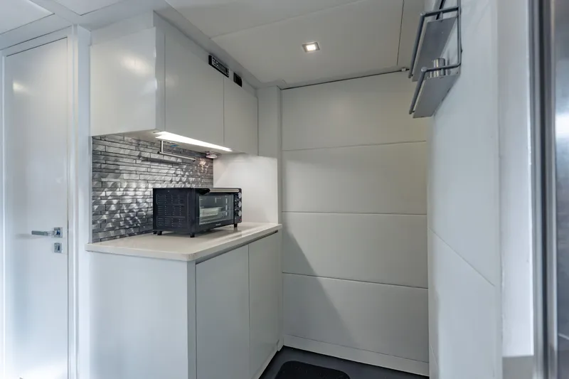 Slide: The Image of Modern kitchen area in a 2010 Pershing 80 yacht with sleek cabinetry and a compact oven. - 84