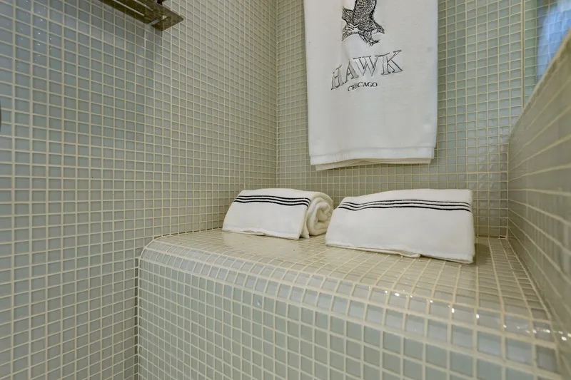 Slide: The Image of Tiled bathroom shelf with folded towels, featuring "Hawk Chicago" embroidery. Pershing 80, 2010 model. - 62