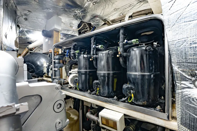 Slide: The Image of Engine room of a 2010 Pershing 80 yacht, showcasing mechanical components and insulation. - 100