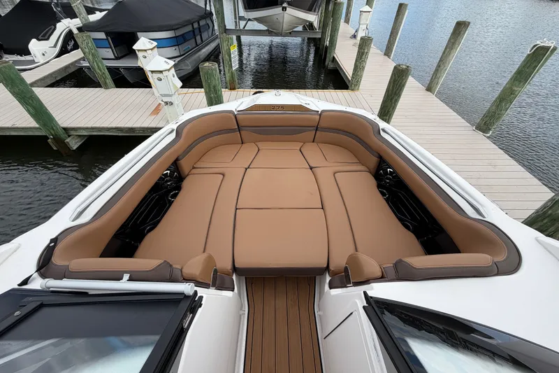 Slide: The Image of 2025 Yamaha Boats 275SD with luxurious tan seating at a marina dock. - 29