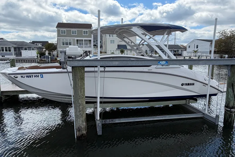 Slide: The Image of 2025 Yamaha Boats 275SD docked in a marina, showcasing sleek design and modern features. - 2