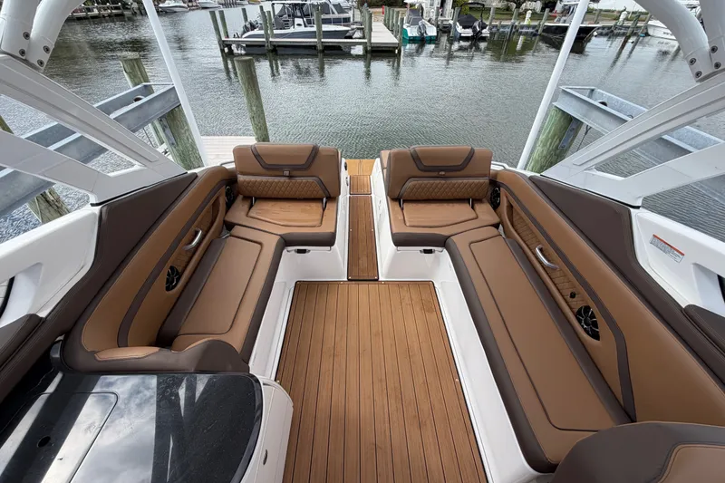 Slide: The Image of Luxurious interior of 2025 Yamaha Boats 275SD with brown leather seating and wood flooring. - 15