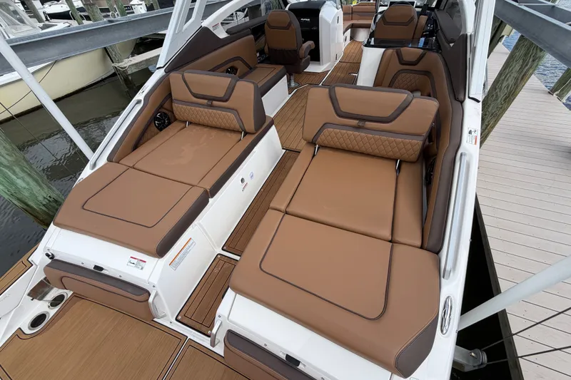 Slide: The Image of 2025 Yamaha Boats 275SD interior with luxurious brown seating and sleek design. - 9