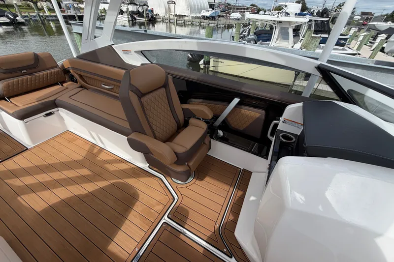 Slide: The Image of Luxurious interior of 2025 Yamaha Boats 275SD with brown leather seating and wood flooring. - 19