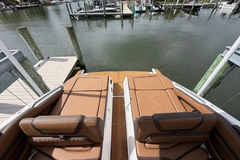 Slide: The Image of 2025 Yamaha Boats 275SD with luxurious tan seating at a marina dock. - 10
