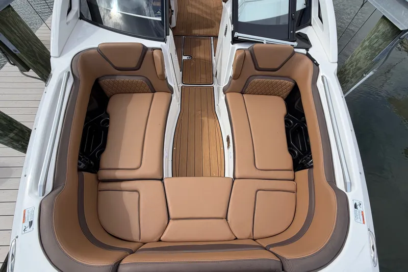 Slide: The Image of 2025 Yamaha Boats 275SD interior with tan leather seating and wood flooring. - 27