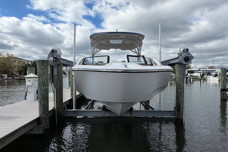 Slide: The Image of 2025 Yamaha Boats 275SD on a lift at a marina, under a cloudy sky. - 4