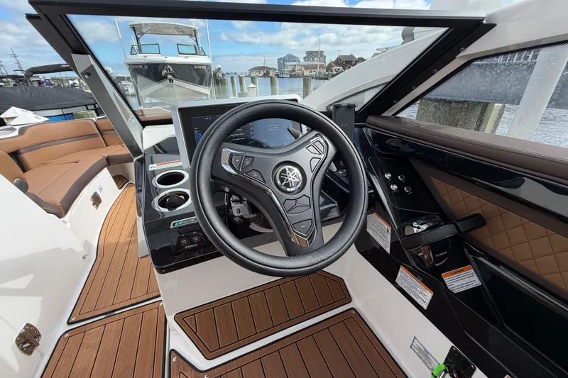 Slide: The Image of 2025 Yamaha Boats 275SD helm with modern steering wheel and dashboard controls. - 22