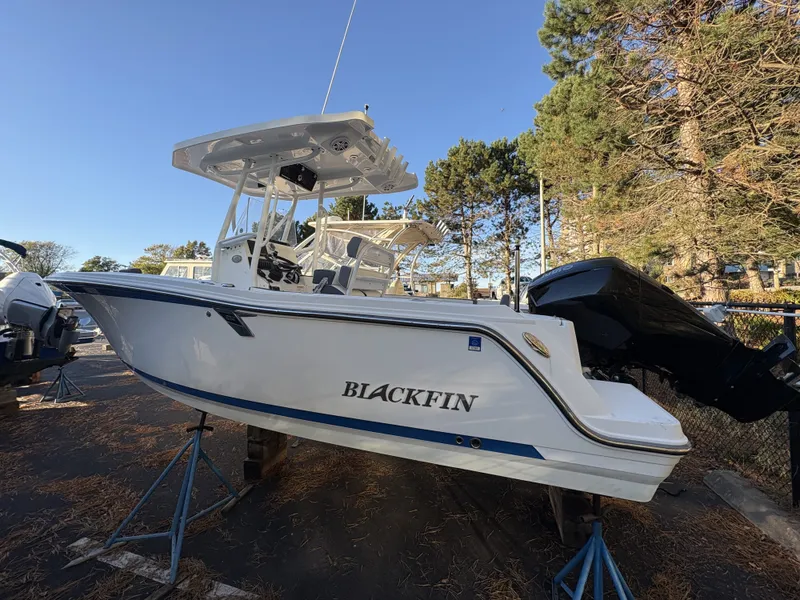 Slide: The Image of A 2019 Blackfin 212 CC boat on stands, surrounded by trees. - 3