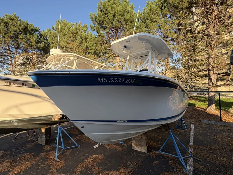 Slide: The Image of A 2019 Blackfin 212 CC boat on stands, surrounded by trees. - 6