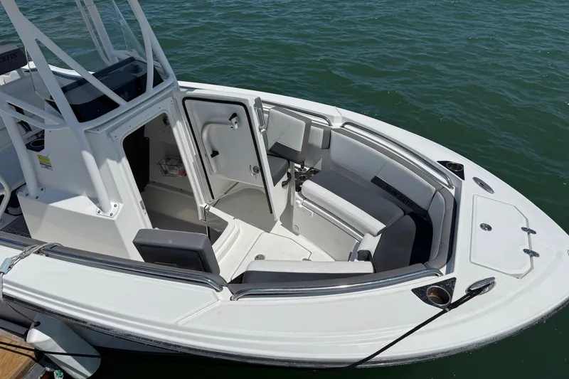 Slide: The Image of 2019 Blackfin 212 CC boat interior with open cabin door, docked on water. - 5