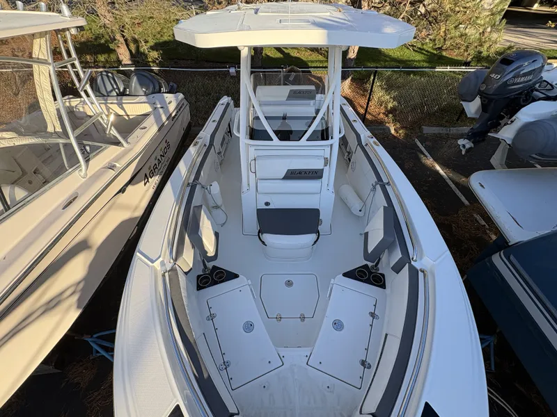 Slide: The Image of A 2019 Blackfin 212 CC boat with a white hull and T-top, parked next to other boats. - 20