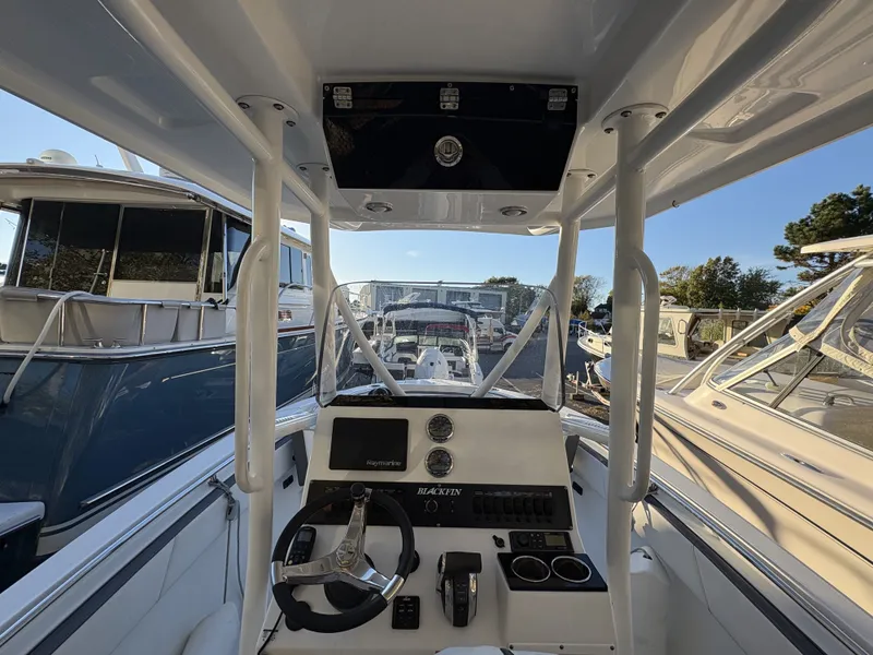 Slide: The Image of The cockpit of a 2019 Blackfin 212 CC with controls and instruments, surrounded by other boats. - 15
