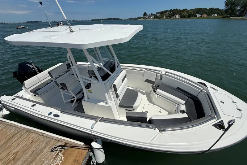 Slide: The Image of 2019 Blackfin 212 CC boat docked on calm water, featuring spacious seating and a sleek design. - 4