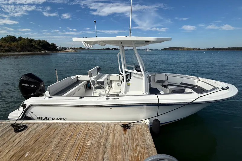 Slide: The Image of 2019 Blackfin 212 CC boat docked on a sunny day with clear blue skies. - 2