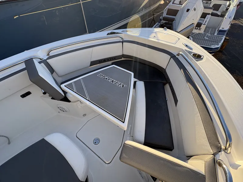 Slide: The Image of The image shows the bow area of a 2019 Blackfin 212 CC with cushioned seating and a table. - 23