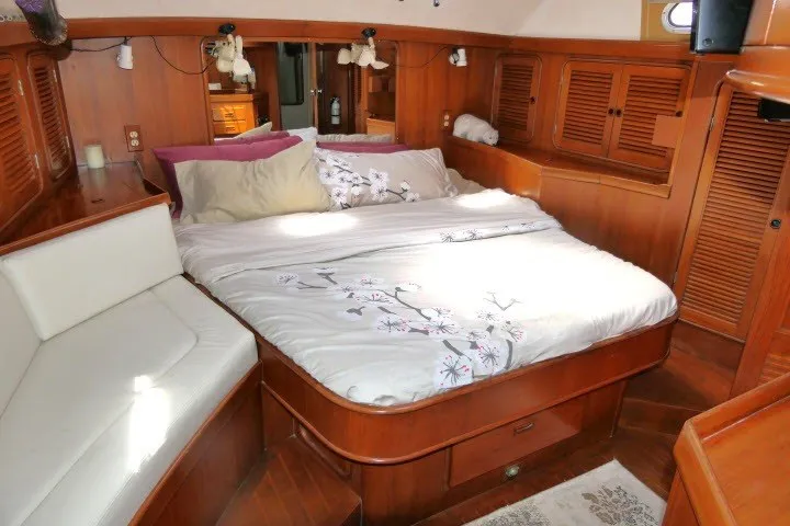 Slide: The Image of Luxurious 1986 Tayana 52 Center Cockpit yacht bedroom with wood paneling and cozy bedding. - 37