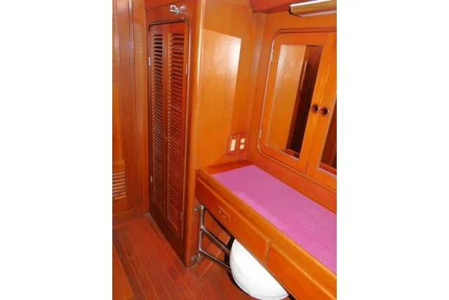 Slide: The Image of Interior of 1986 Tayana 52 Center Cockpit yacht with wooden cabinetry and purple cushioned bench. - 27