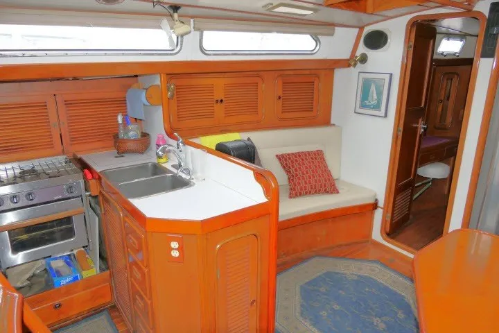 Slide: The Image of Interior of 1986 Tayana 52 Center Cockpit yacht with kitchen and seating area. - 4