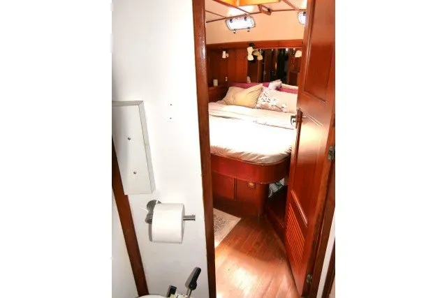 Slide: The Image of Interior of 1986 Tayana 52 Center Cockpit yacht, featuring cozy bedroom and wooden finishes. - 49