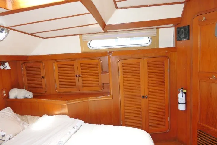 Slide: The Image of 1986 Tayana 52 Center Cockpit interior with wooden cabinetry and cozy sleeping area. - 40