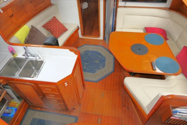 Slide: The Image of Interior of 1986 Tayana 52 Center Cockpit yacht with cozy seating and wooden finishes. - 2