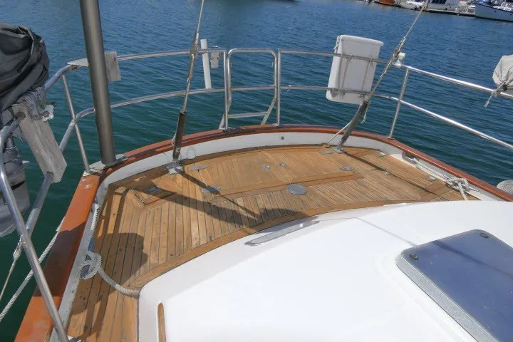 Slide: The Image of 1986 Tayana 52 Center Cockpit sailboat deck with wooden finish, docked at marina. - 61