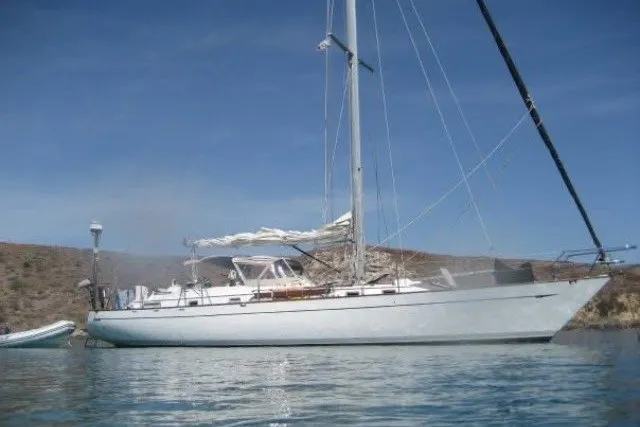 Slide: The Image of 1986 Tayana 52 Center Cockpit sailboat anchored on calm water under clear blue sky. - 90