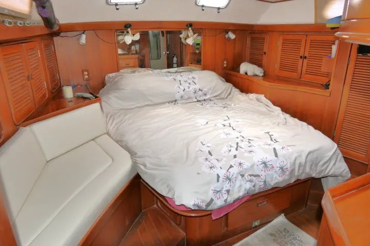 Slide: The Image of Cozy bedroom in 1986 Tayana 52 Center Cockpit yacht with wood paneling and floral bedding. - 36
