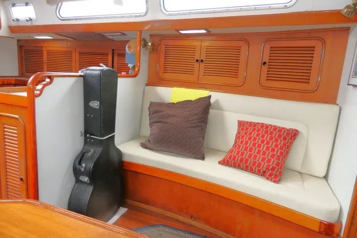 Slide: The Image of Interior of 1986 Tayana 52 Center Cockpit with cushioned seating and guitar case. - 8