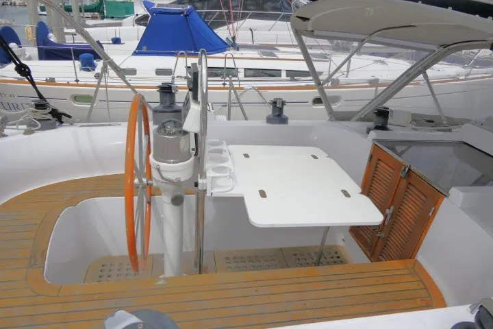 Slide: The Image of 1986 Tayana 52 Center Cockpit sailboat with wooden deck and orange steering wheel. - 55