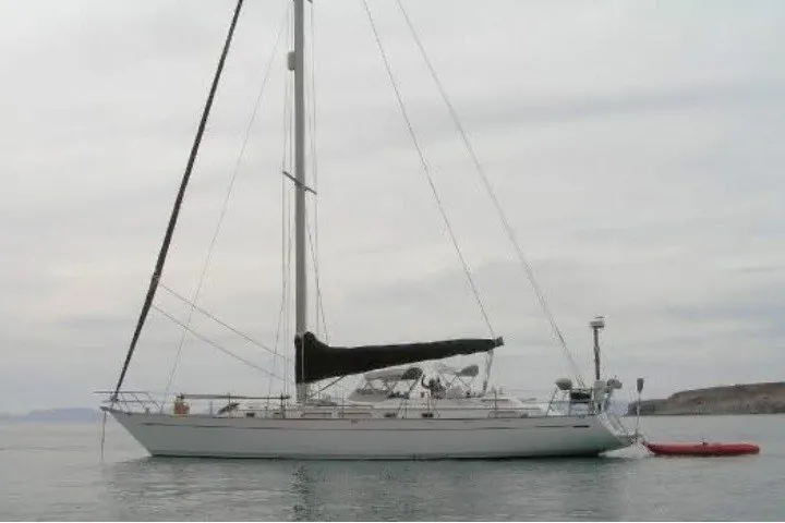 Slide: The Image of 1986 Tayana 52 Center Cockpit sailboat anchored on calm water. - 91
