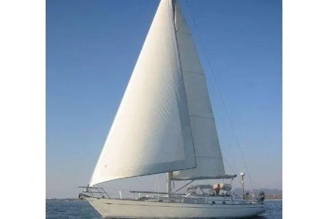 Slide: The Image of 1986 Tayana 52 Center Cockpit sailboat with full sails on open water. - 89