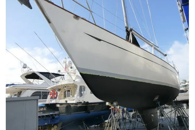 Slide: The Image of 1986 Tayana 52 Center Cockpit sailboat on dry dock, showcasing sleek hull design. - 70