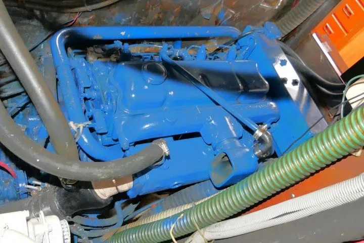 Slide: The Image of Engine compartment of a 1986 Tayana 52 Center Cockpit sailboat, featuring a blue-painted engine. - 79